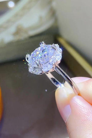 a person holding a diamond ring in their hand
