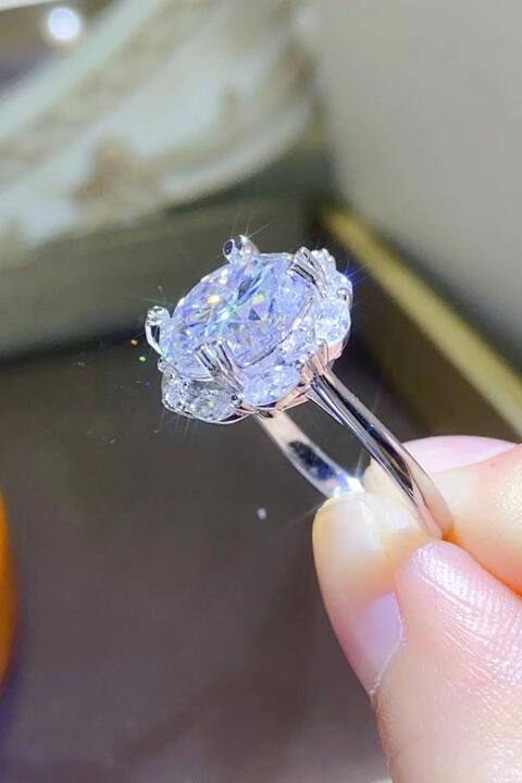a person holding a diamond ring in their hand