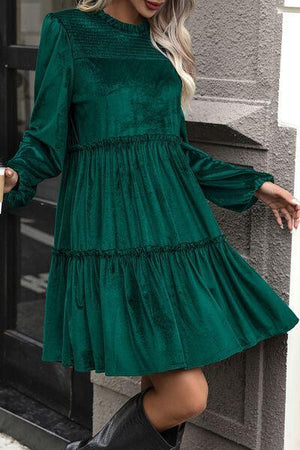 a woman wearing a green dress and black boots