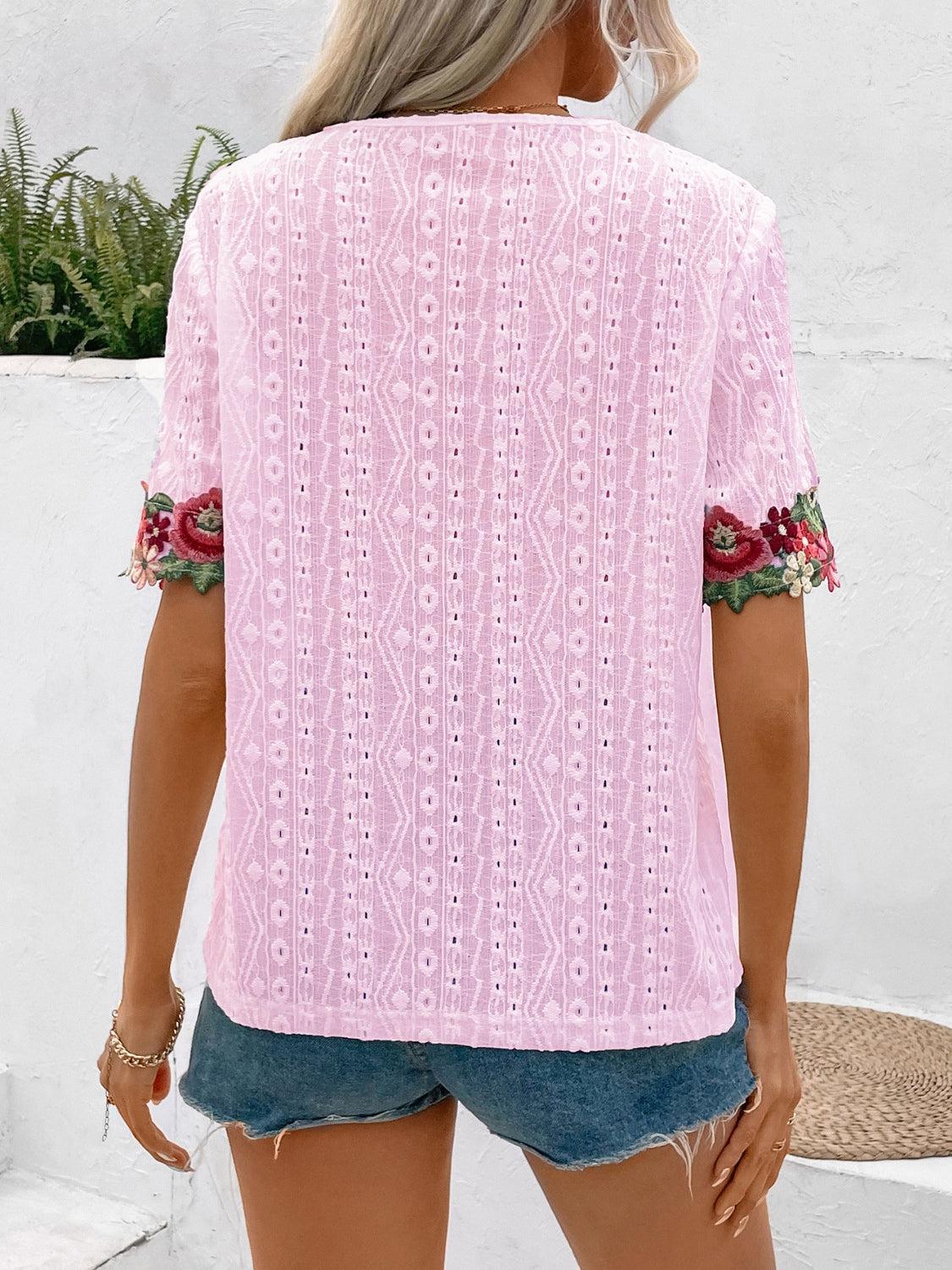 a woman wearing a pink top and denim shorts