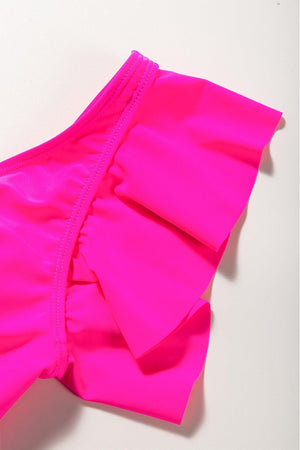 a close up of a pink swimsuit on a white surface