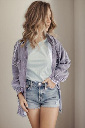 a woman in a white shirt and denim shorts