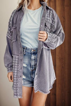 a woman wearing a gray jacket and denim shorts