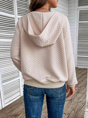 a woman wearing a pink hoodie and jeans