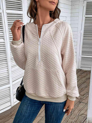 a woman wearing a white hoodie and jeans