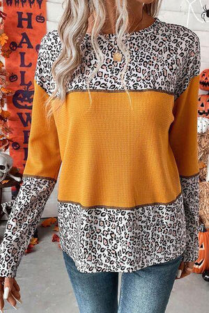a woman wearing a leopard print sweater and jeans