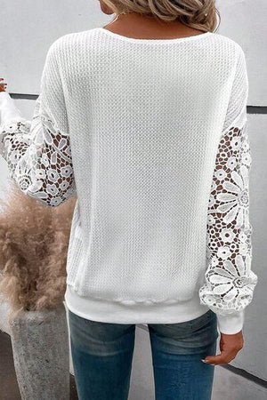 a woman wearing a white sweater and jeans