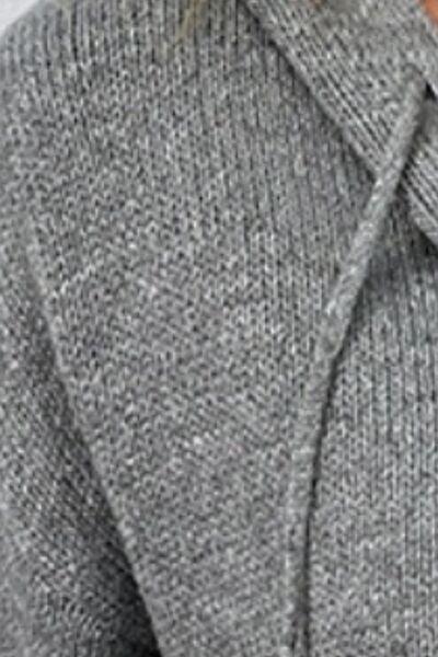 a close up of a person wearing a gray sweater
