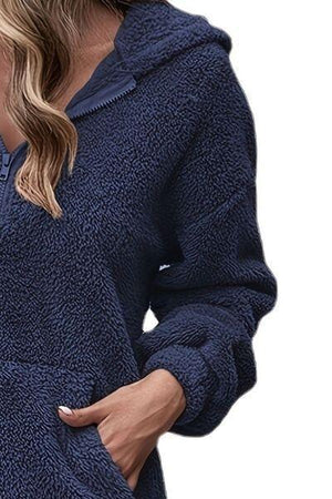 a woman wearing a blue hoodie and jeans