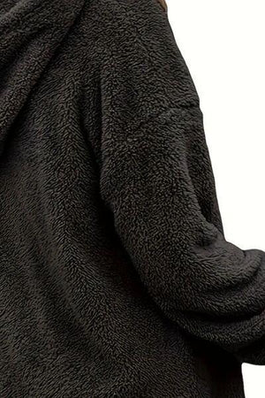 a woman wearing a black coat with a hood