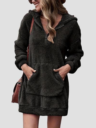 a woman wearing a black hooded sweatshirt dress