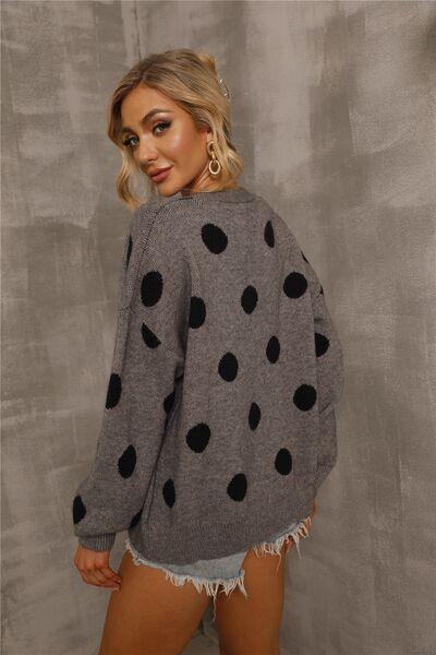 a woman wearing a grey sweater with black polka dots