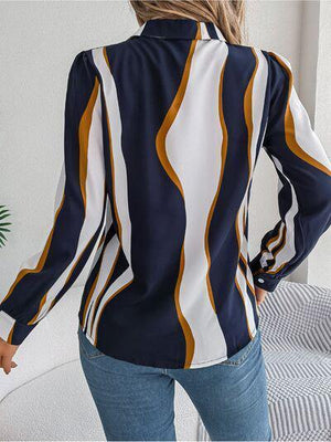 a woman wearing a blue and white shirt and jeans