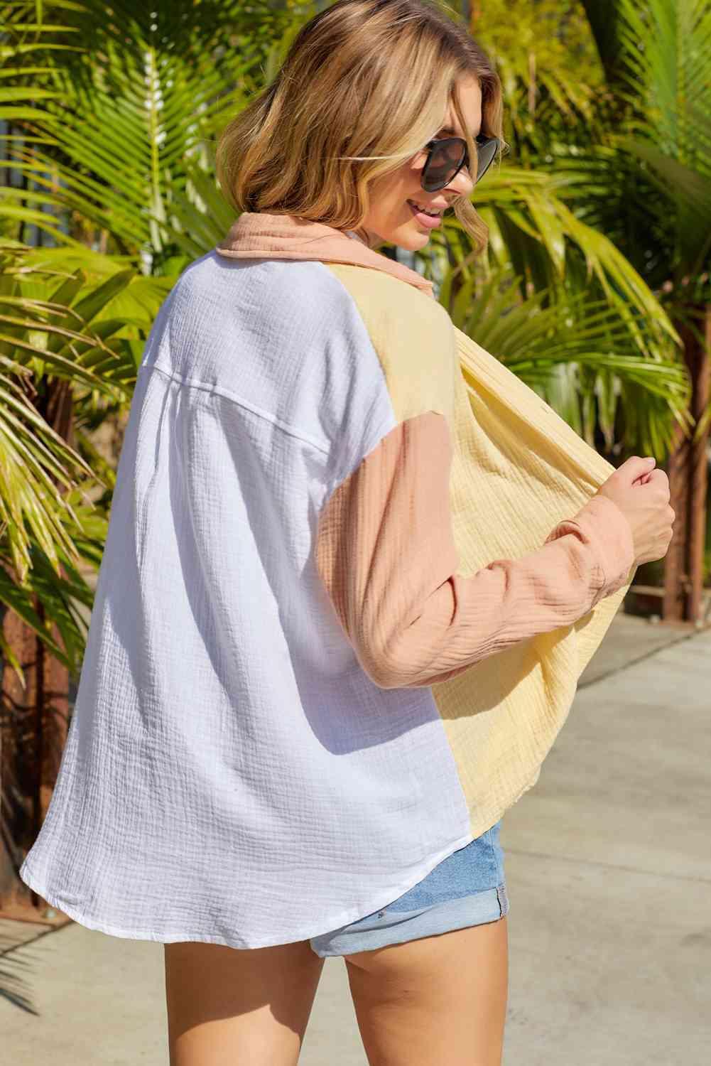 a woman walking down a sidewalk carrying a bag