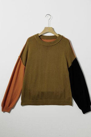 a brown and black sweater hanging on a hanger