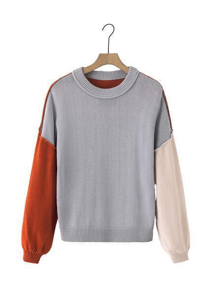 a grey sweater with an orange and white sleeve