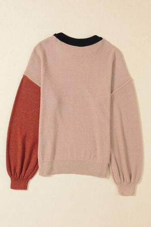 a pink sweater with a red and black color block