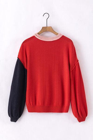 a red and black sweater hanging on a hanger