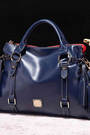 a blue handbag with tassels on the handles