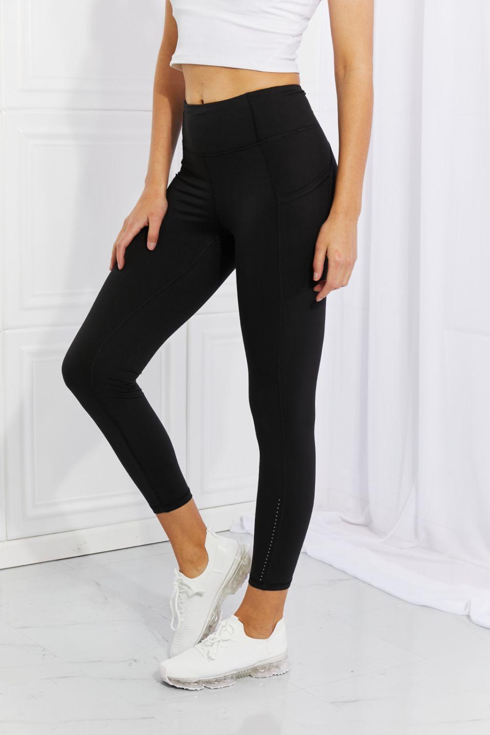 a woman in a white top and black leggings