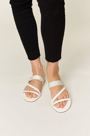 a woman in black pants and white sandals