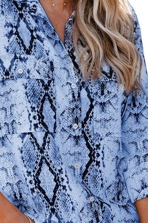 a woman wearing a blue snake skin shirt