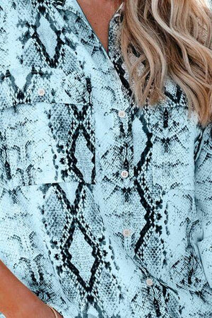 a woman wearing a blue snakeskin blouse