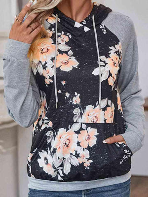 a woman with blonde hair wearing a floral hoodie