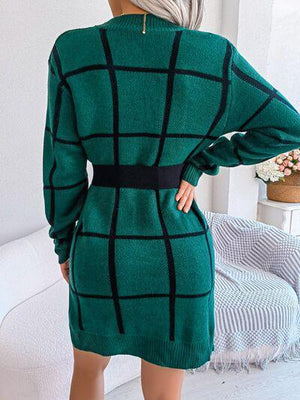 a woman wearing a green sweater dress with a black belt
