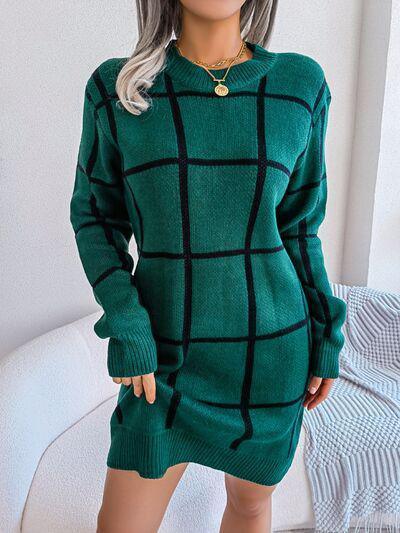 a woman in a green sweater dress posing for a picture