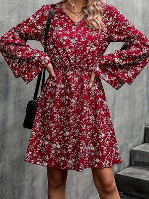 a woman wearing a red floral print dress