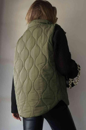 a woman wearing a green quilted vest