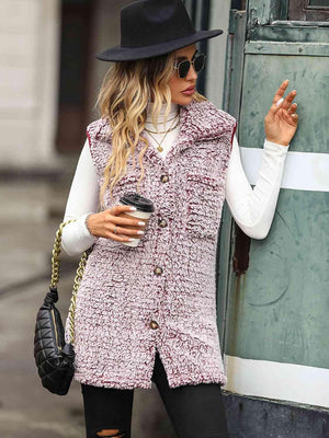 a woman in a hat and vest holding a cup of coffee