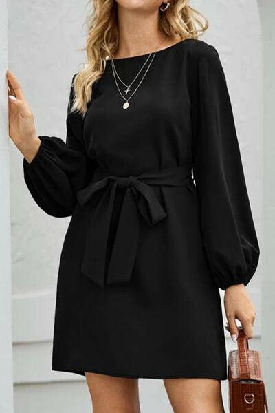 a woman in a black dress with a brown purse