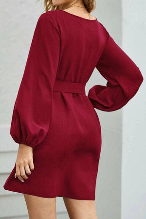 a woman wearing a red dress with long sleeves