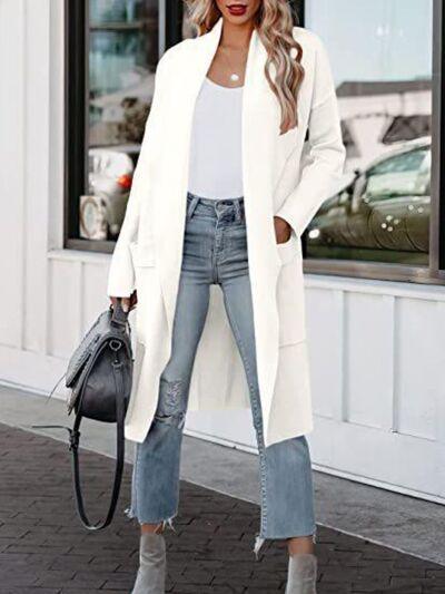 a woman wearing a white coat and jeans