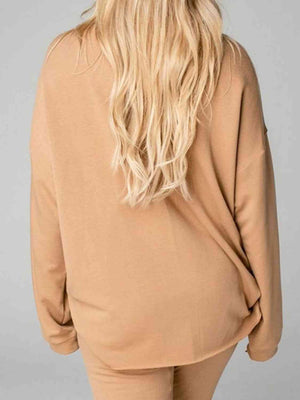 a woman with blonde hair wearing a tan sweater