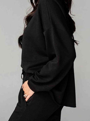 a woman wearing a black sweater and black pants