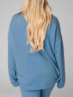 a woman with long blonde hair wearing a blue top