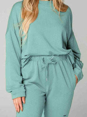 a woman wearing a green sweatshirt and pants