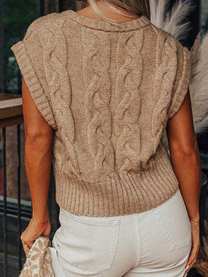 a woman wearing a sweater and white pants