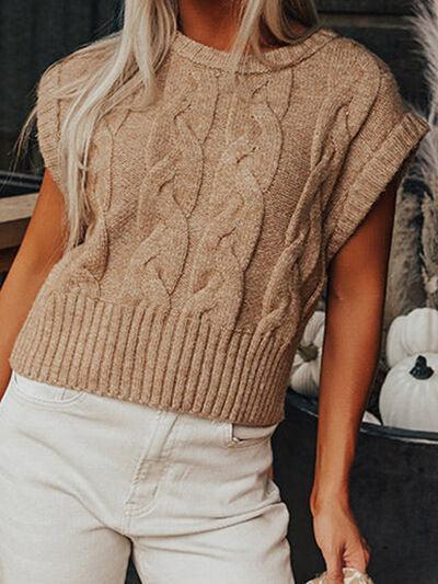 a woman wearing a tan sweater and white pants