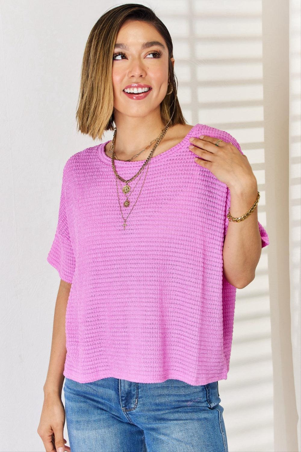 a woman wearing a pink sweater and jeans