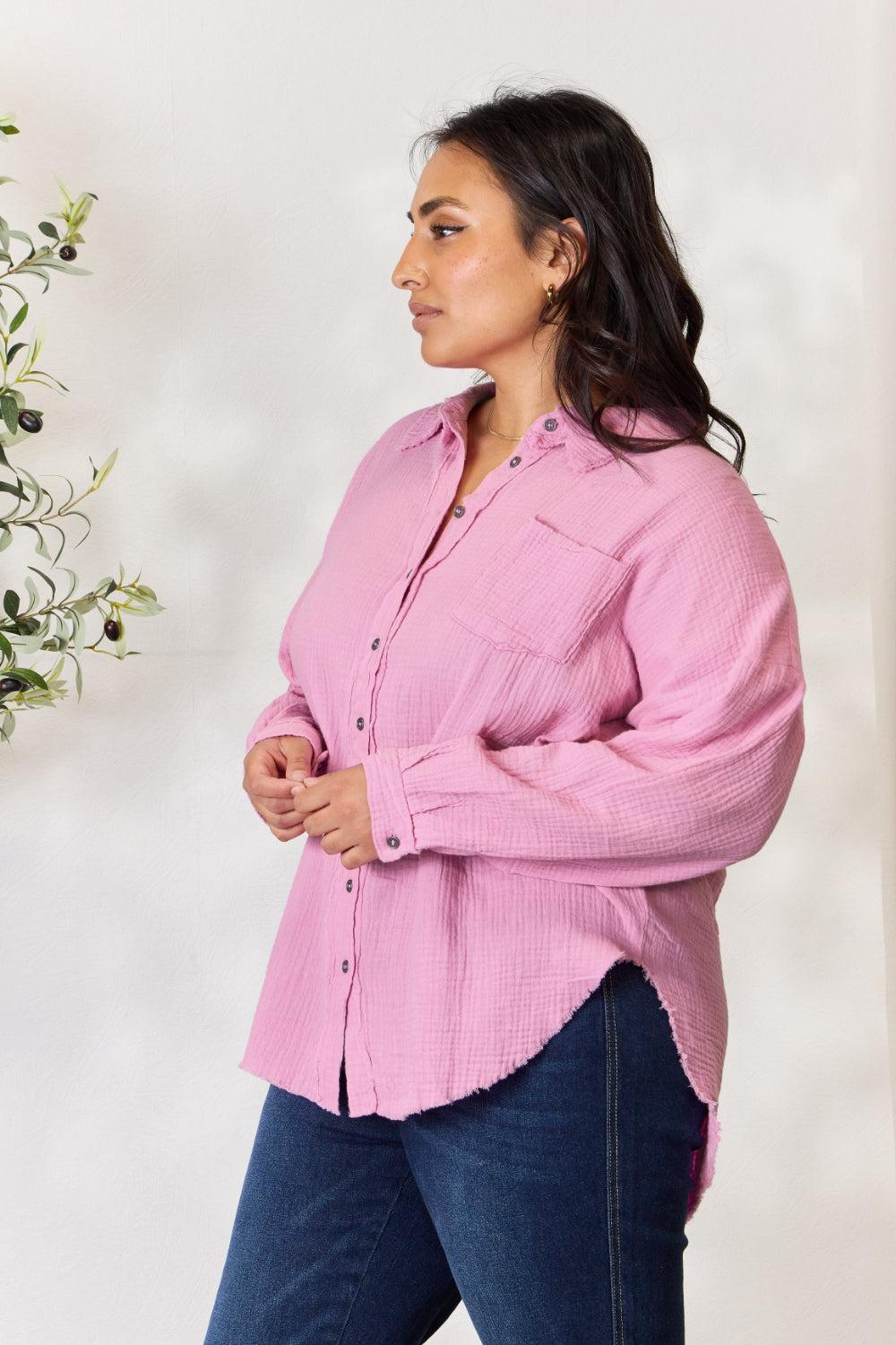 a woman in a pink shirt is standing in front of a plant