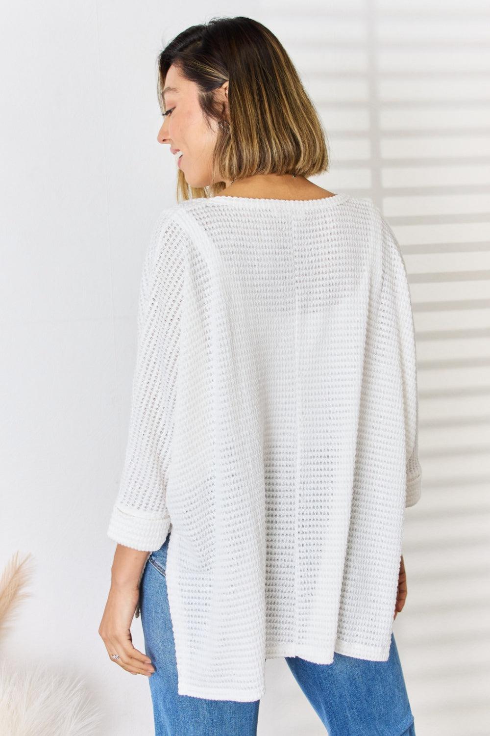 a woman wearing a white sweater and jeans
