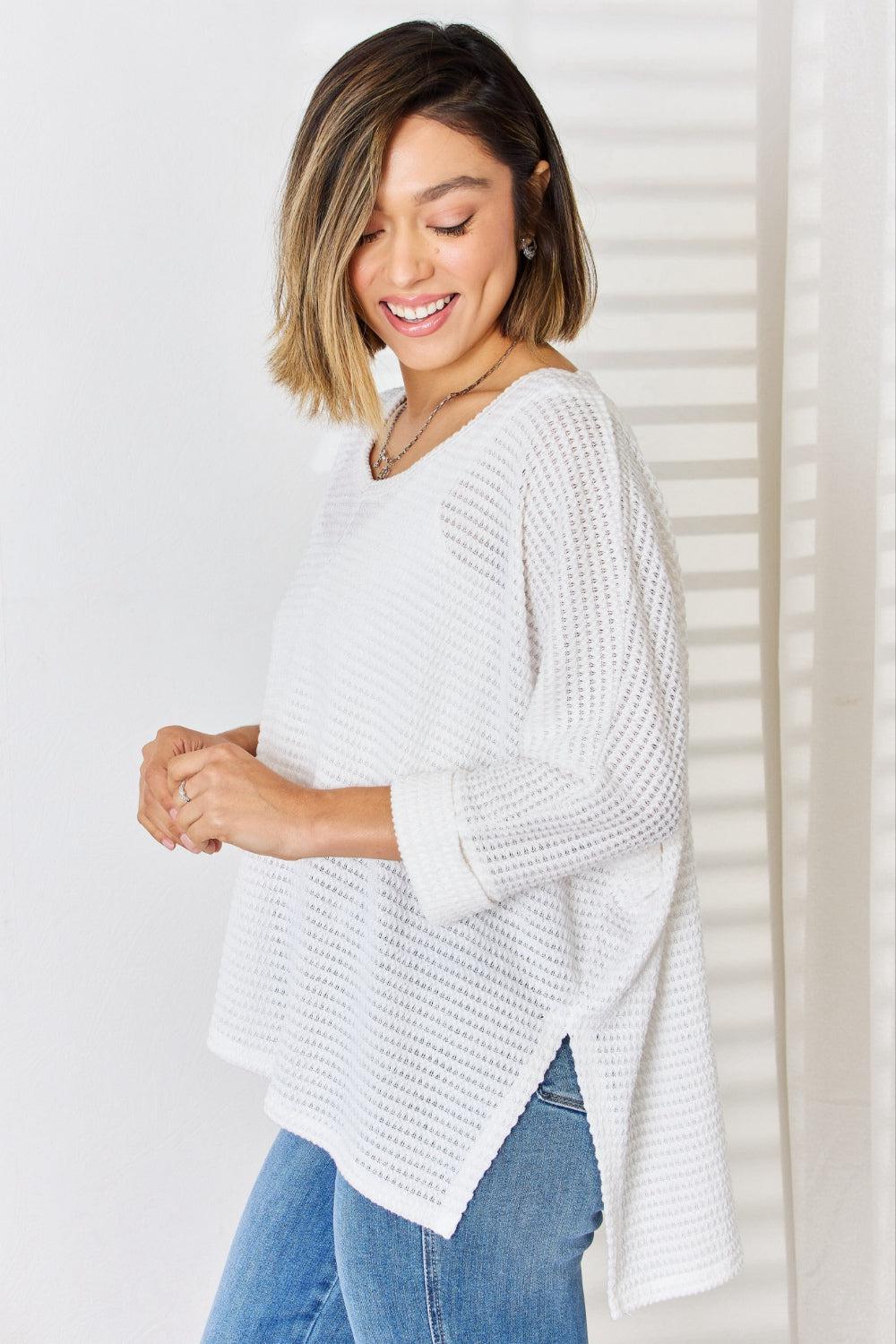 a woman wearing a white sweater and jeans