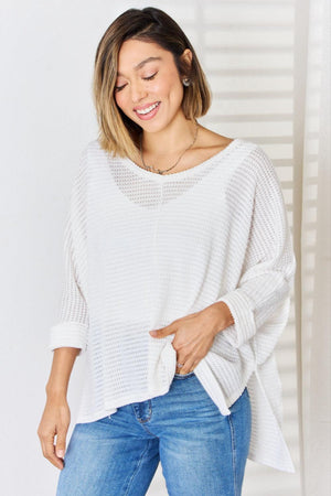 a woman wearing a white sweater and jeans