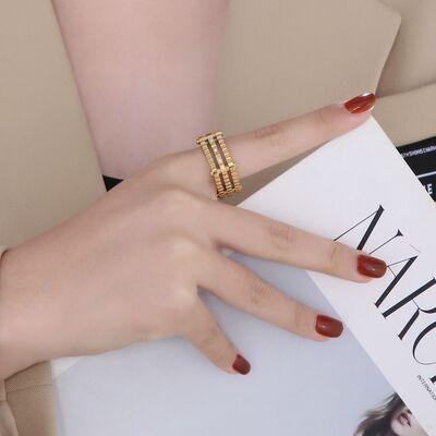 a woman's hand holding a magazine with a gold ring on it