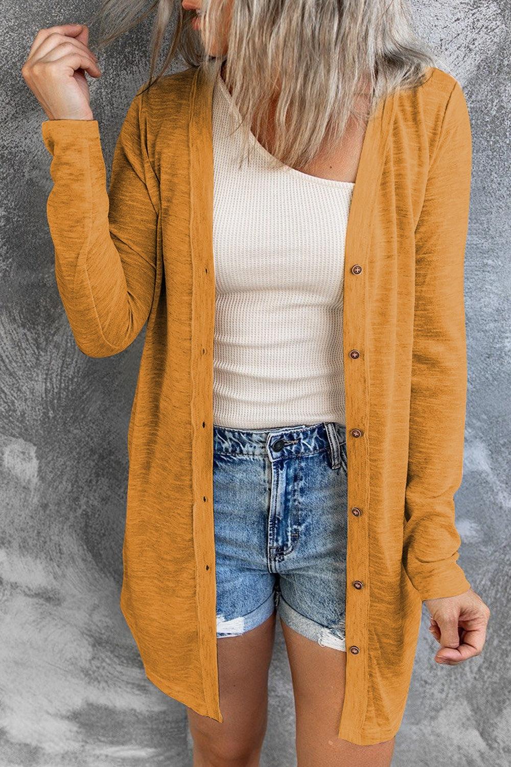 a woman wearing a yellow cardigan and denim shorts
