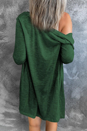 a woman wearing a green sweater and jeans